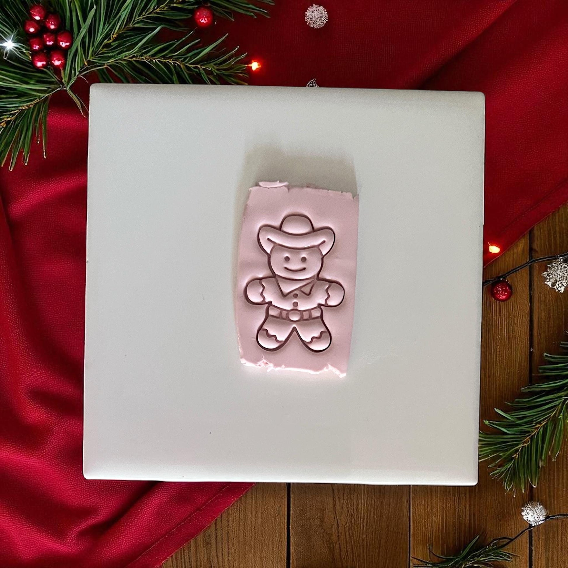 Cowboy gingerbread man clay imprint with holiday greenery and ornaments