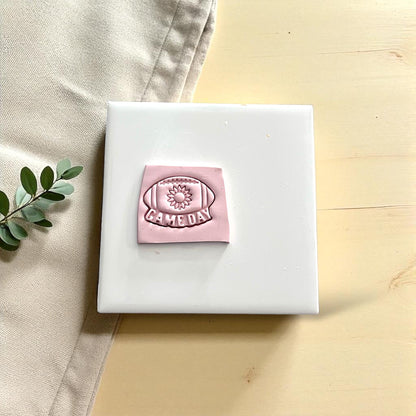 Game day sunflower football polymer clay imprint on white tile
