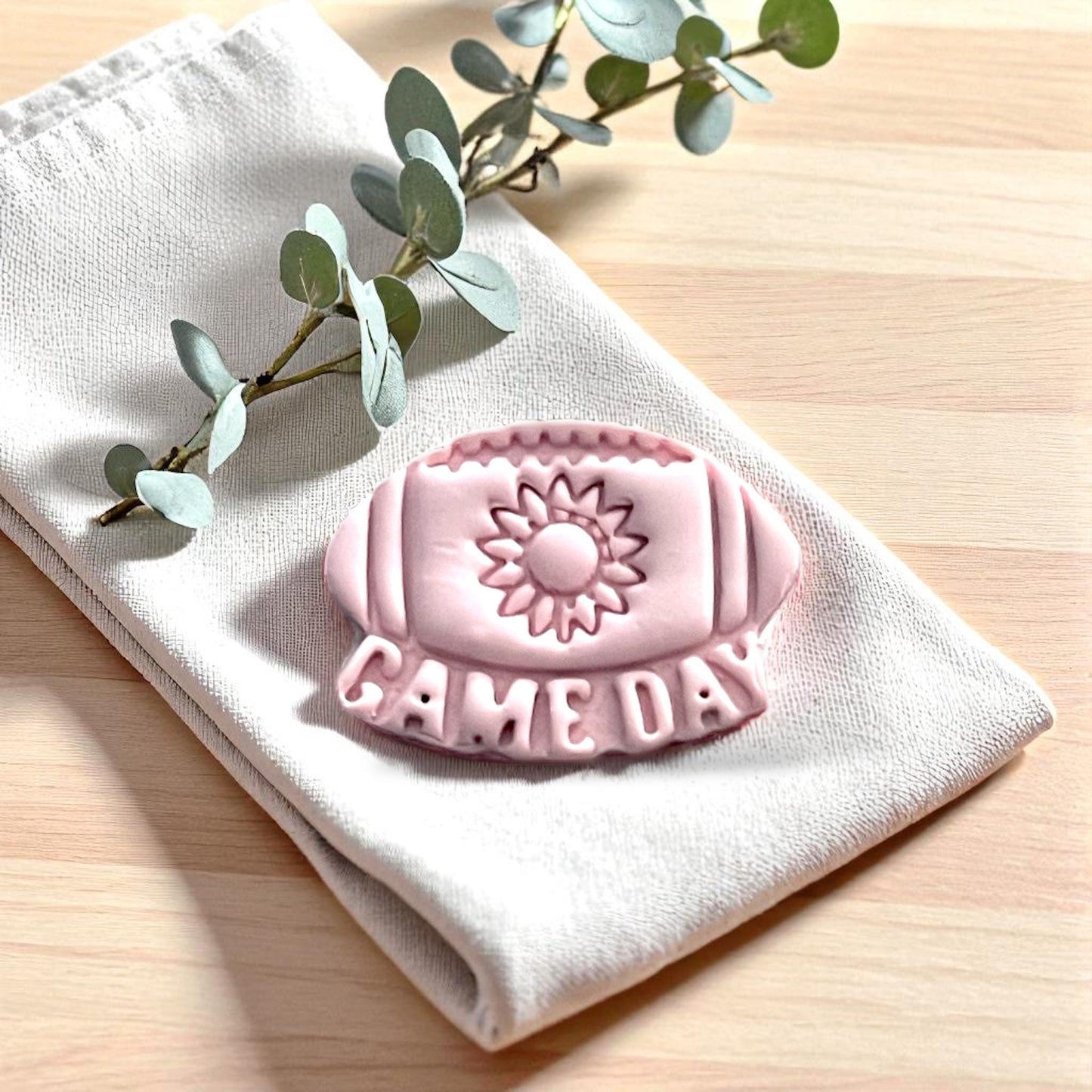 Pink sunflower football game day clay imprint on fabric with leaves