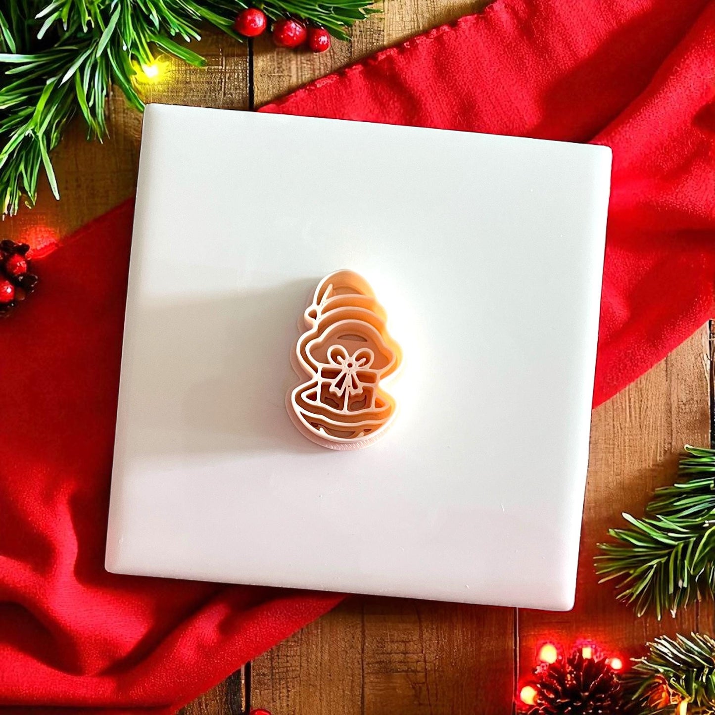 Polymer clay oyster gift cutter on white tile with Christmas greenery