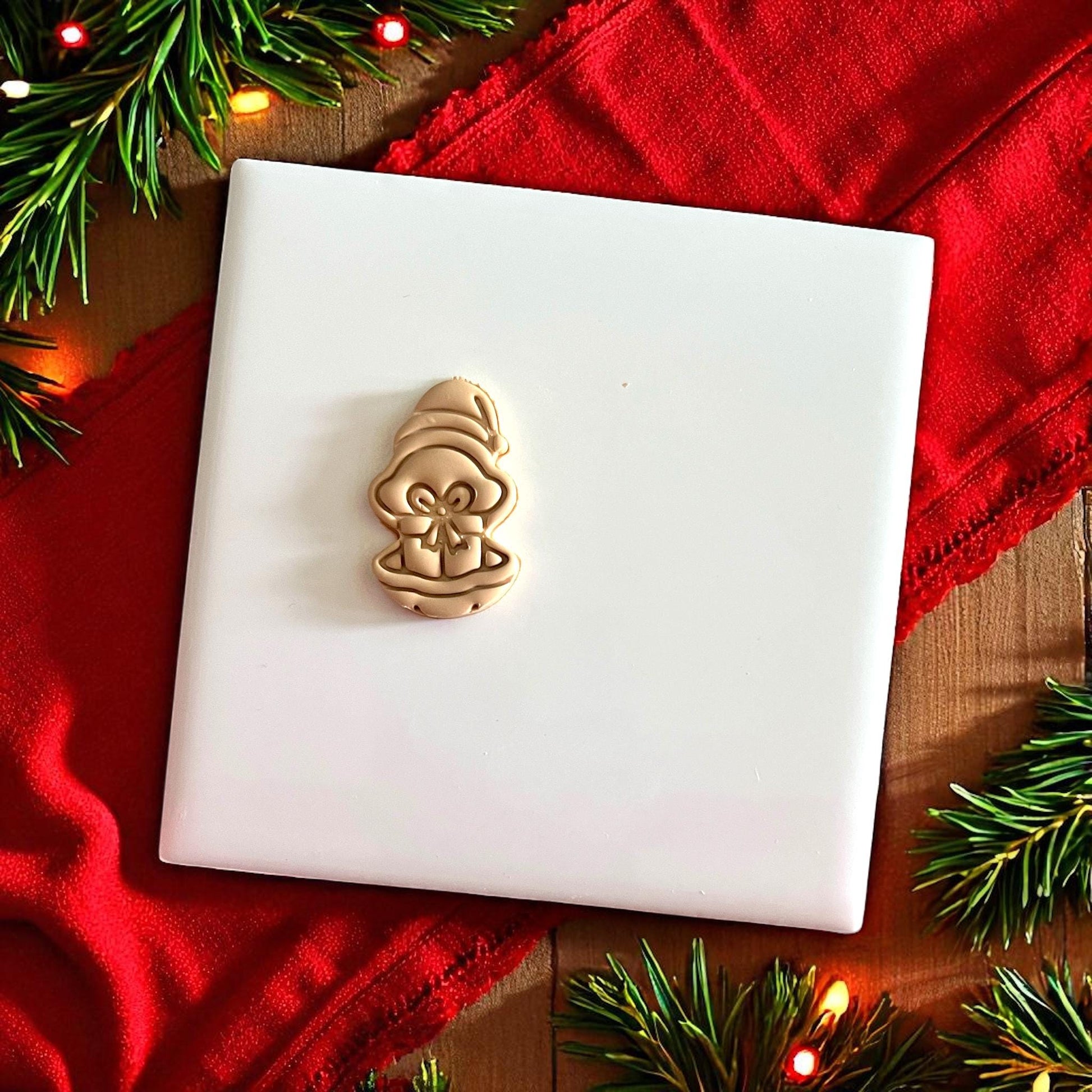 Polymer clay oyster present design shown on white tile with red background