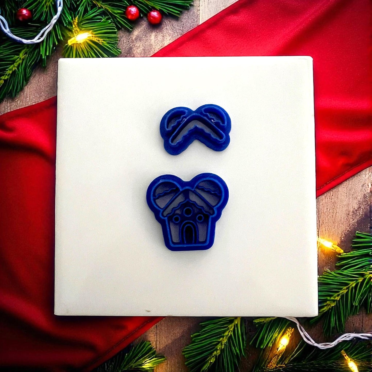 Blue gingerbread mouse house cutters on white tile with Christmas greenery