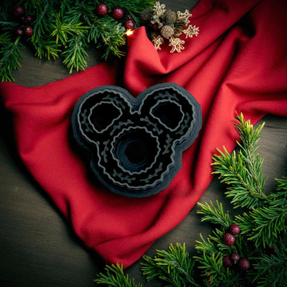 black wreath-shaped clay cutter on white tile with red background