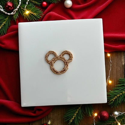 clay impression of wreath-shaped cutter with festive red backdrop