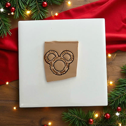 festive close-up of black wreath polymer clay cutter on red fabric and pine branches