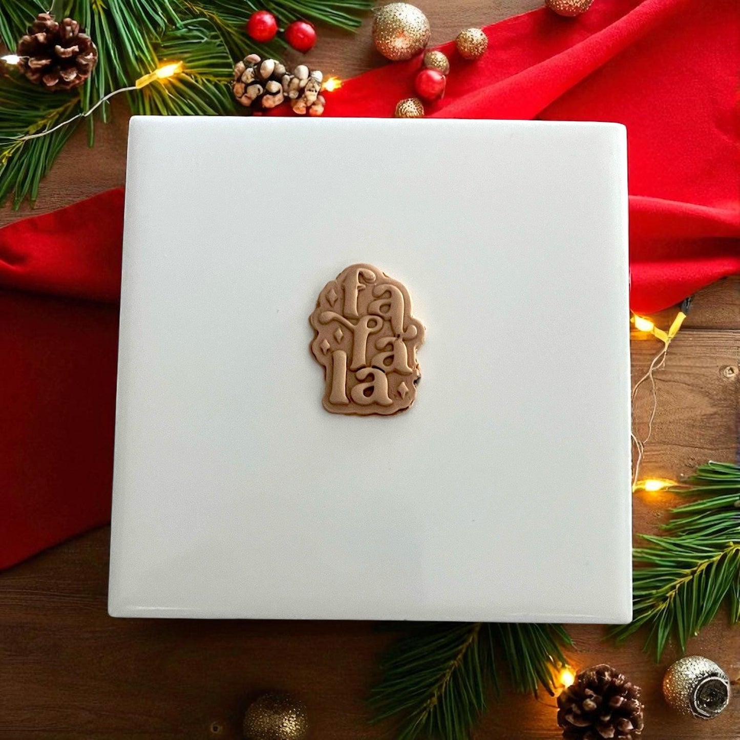 Fa La La clay impression on white tile with gold and red Christmas decor