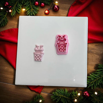 Pink Santa chimney clay imprint and cutter side by side on white tile