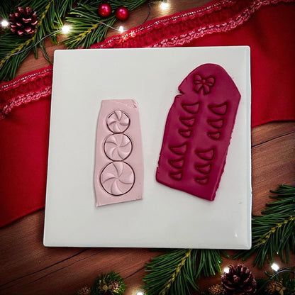 Pink and red clay imprints of peppermint candy snowman with bow cutter on white tile