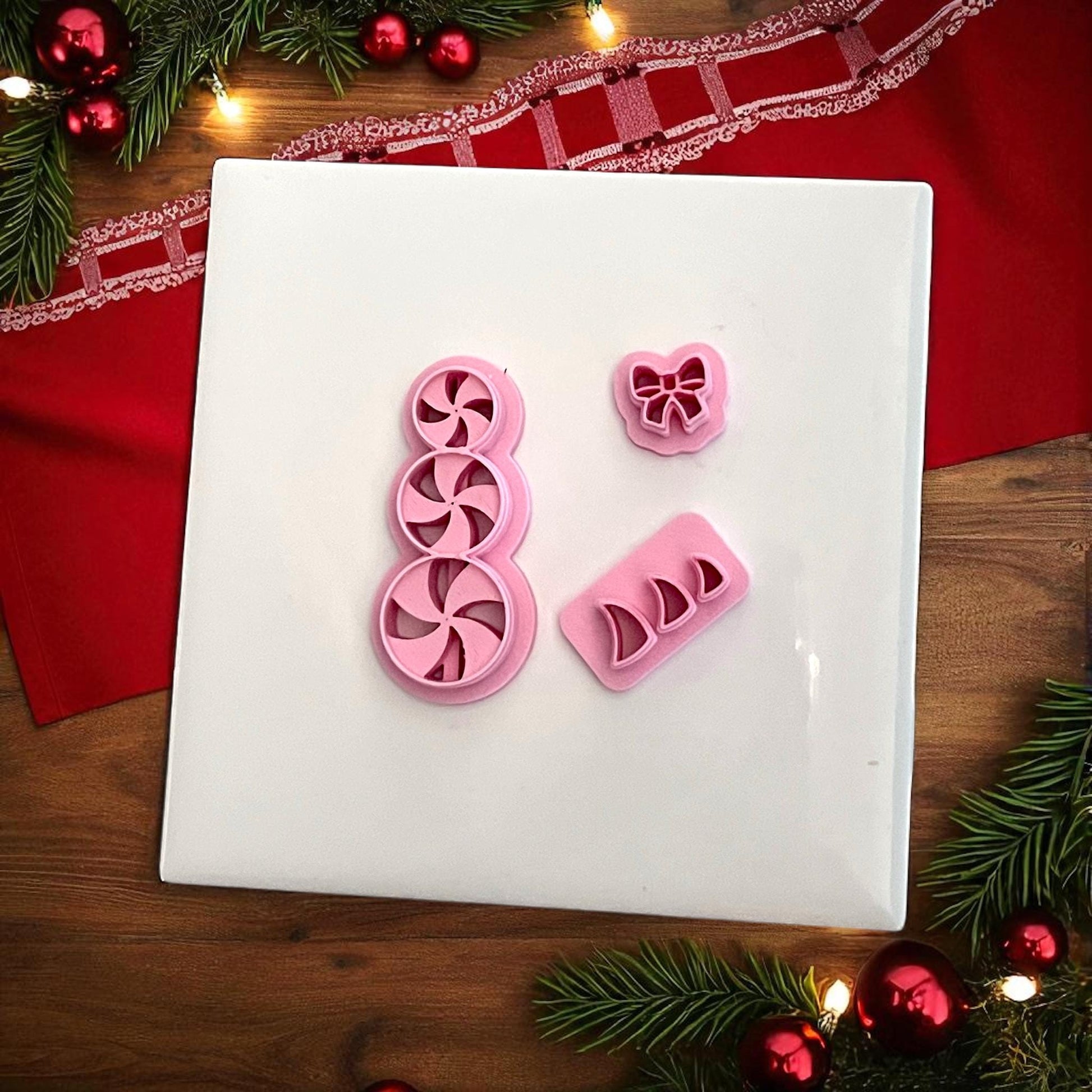 Peppermint candy snowman polymer clay cutter set with bow and swirl pieces on white tile