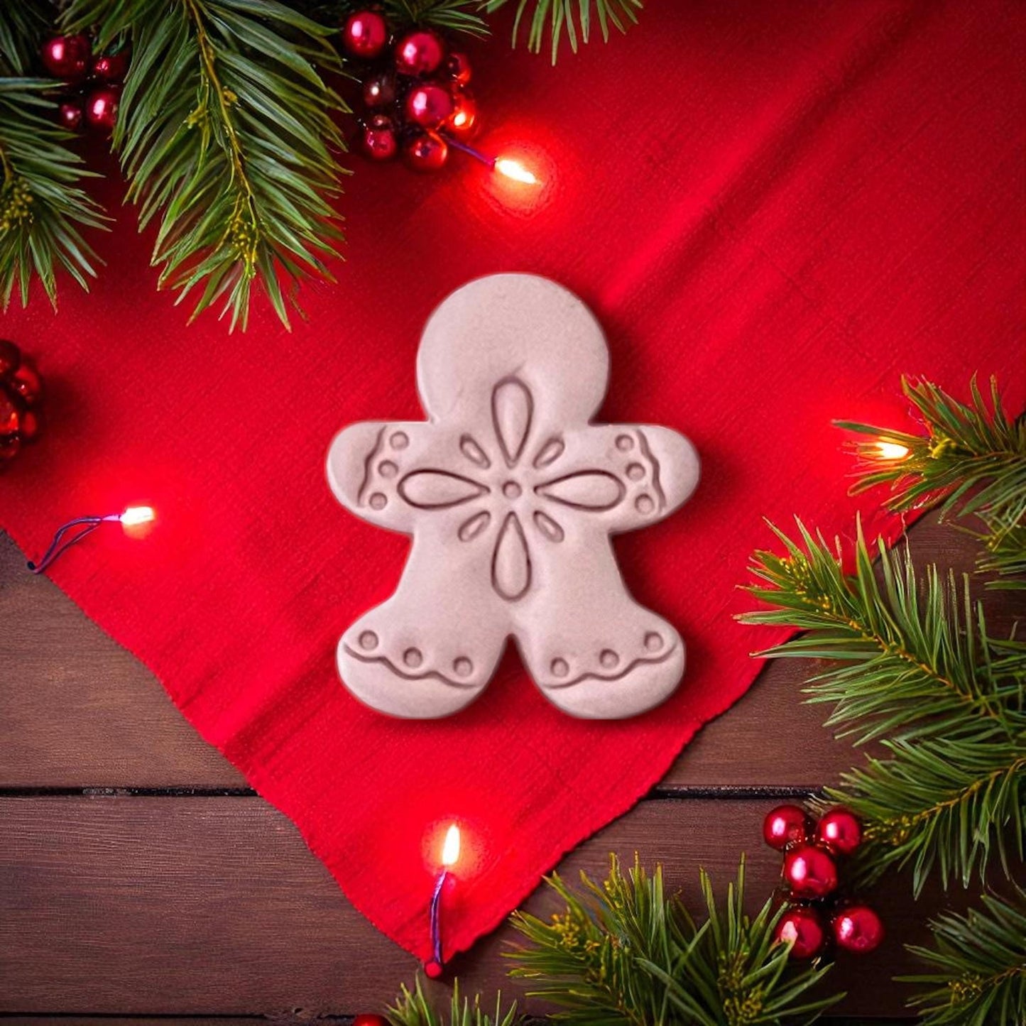 Boho gingerbread man clay shape with detailed design on red cloth