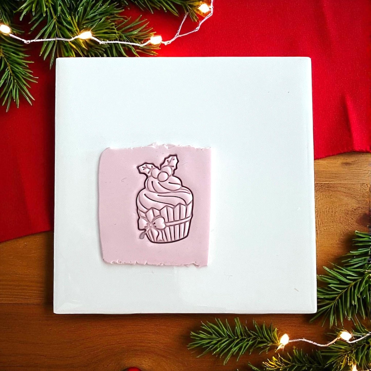 Christmas cupcake polymer clay cutter imprint in pink clay with holly design