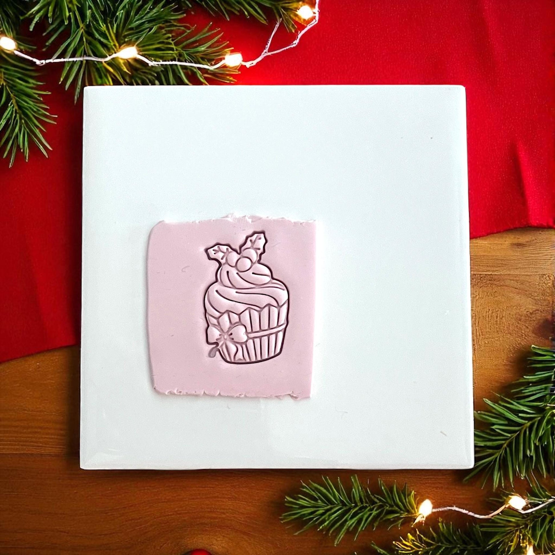 Christmas cupcake polymer clay cutter imprint in pink clay with holly design