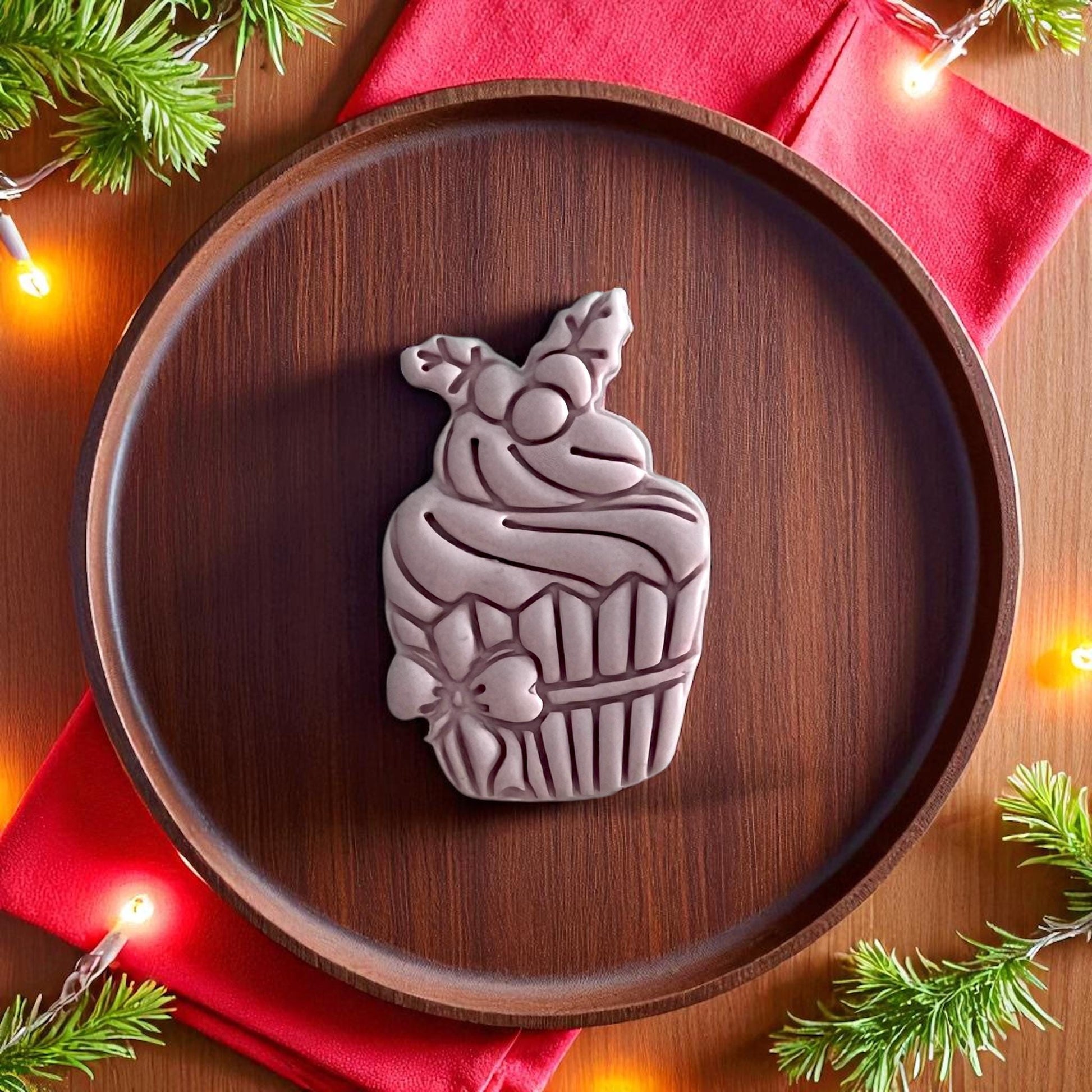 Large Christmas cupcake clay piece on wooden plate with red napkin