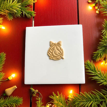 Holiday cardinal clay imprint on white tile with red background and string lights