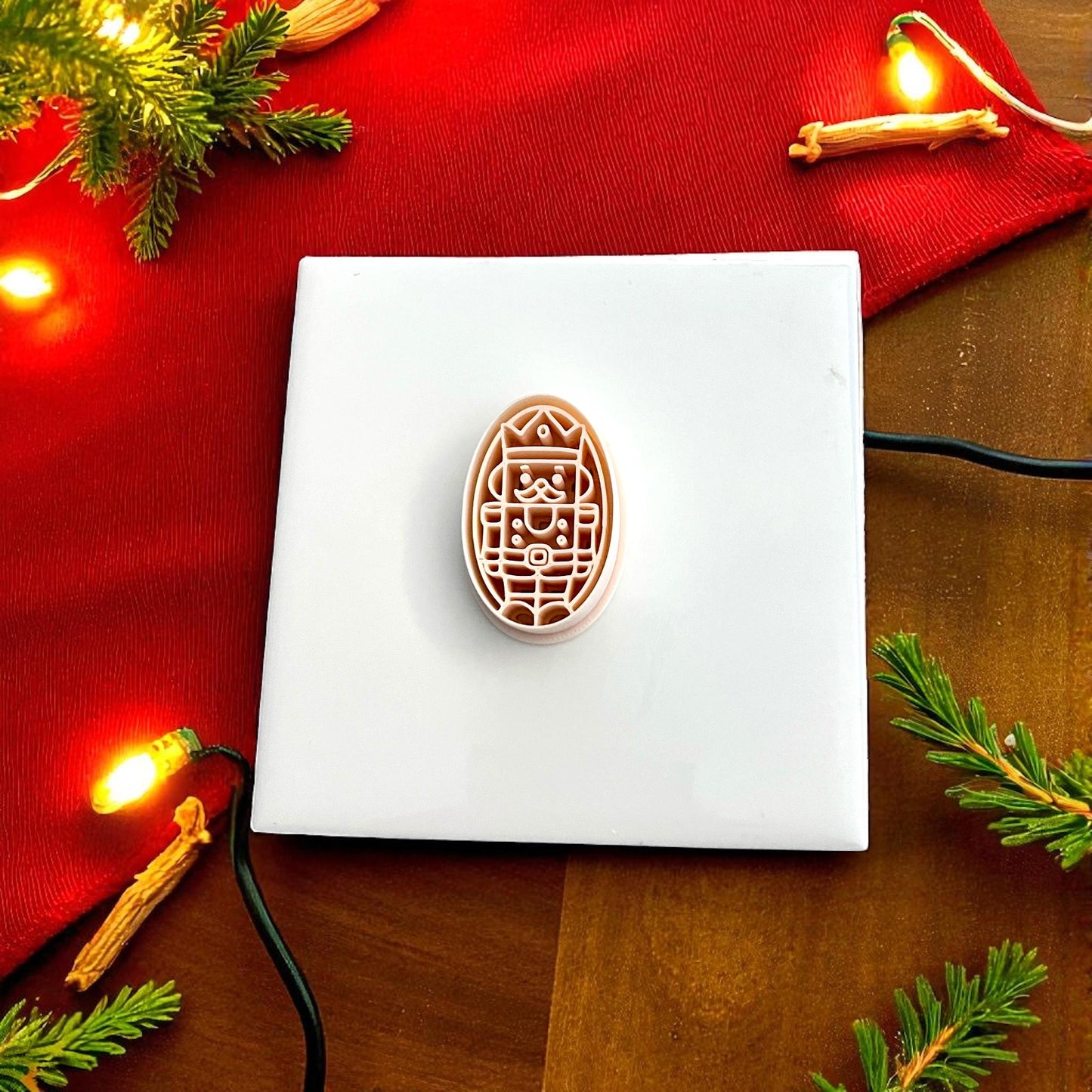 Nutcracker polymer clay cutter displayed on red cloth with lights