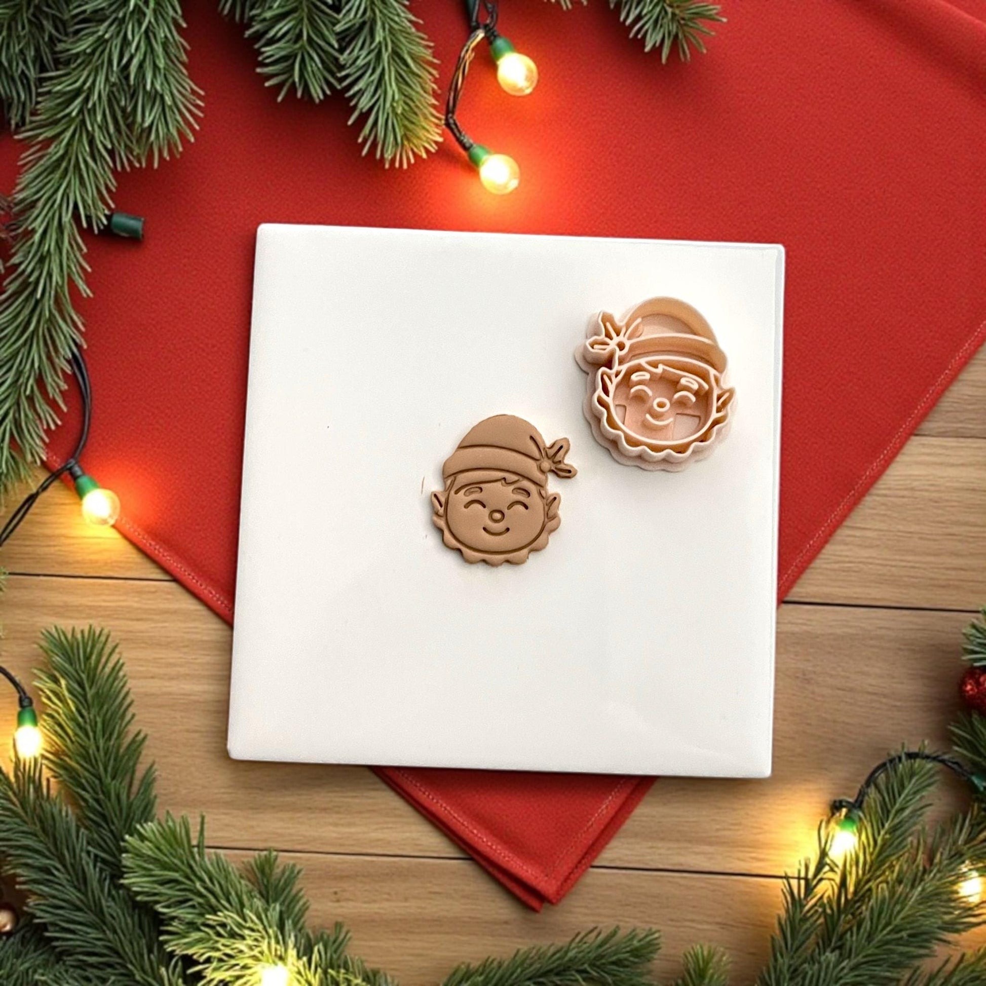 Elf polymer clay cutter and clay imprint side by side with pine branches and red napkin