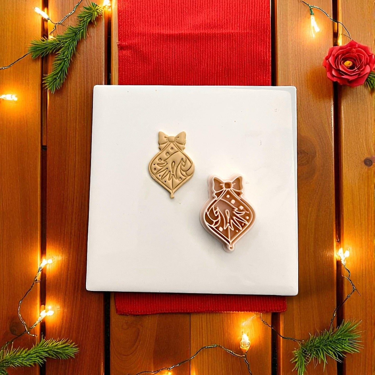 Polymer clay cutter and ornament imprint with festive red backdrop and lights