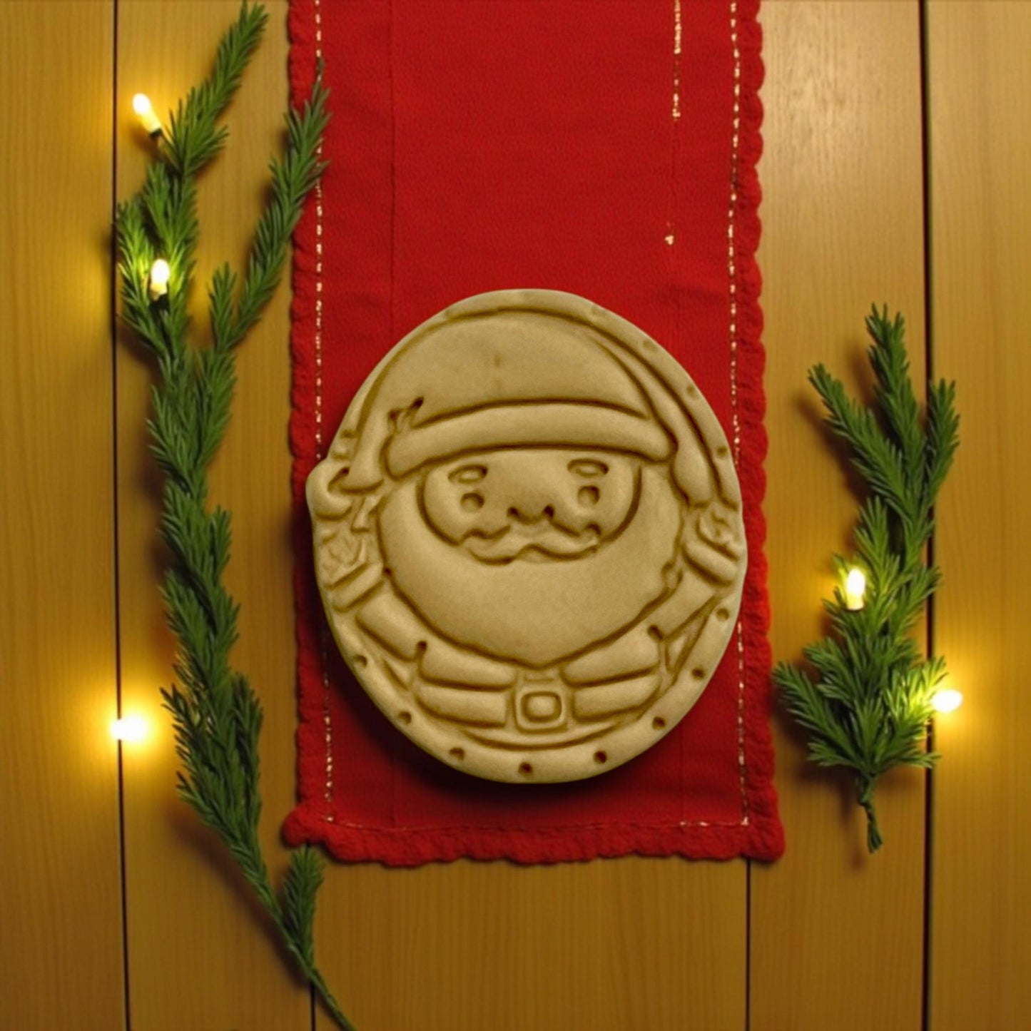 Santa Claus clay imprint on red mat with pine branches