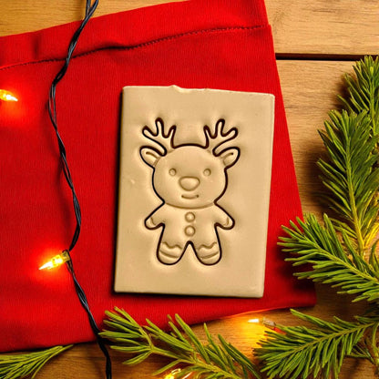 Gingerbread reindeer polymer clay imprint on red fabric with Christmas lights