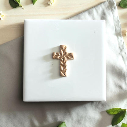 Small ivy cross impression on white tile with greenery