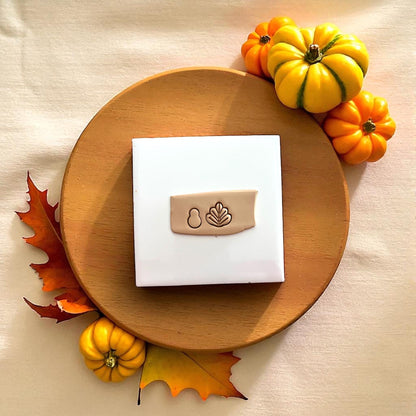 Polymer clay turkey design on wooden plate with pumpkin and autumn leaves