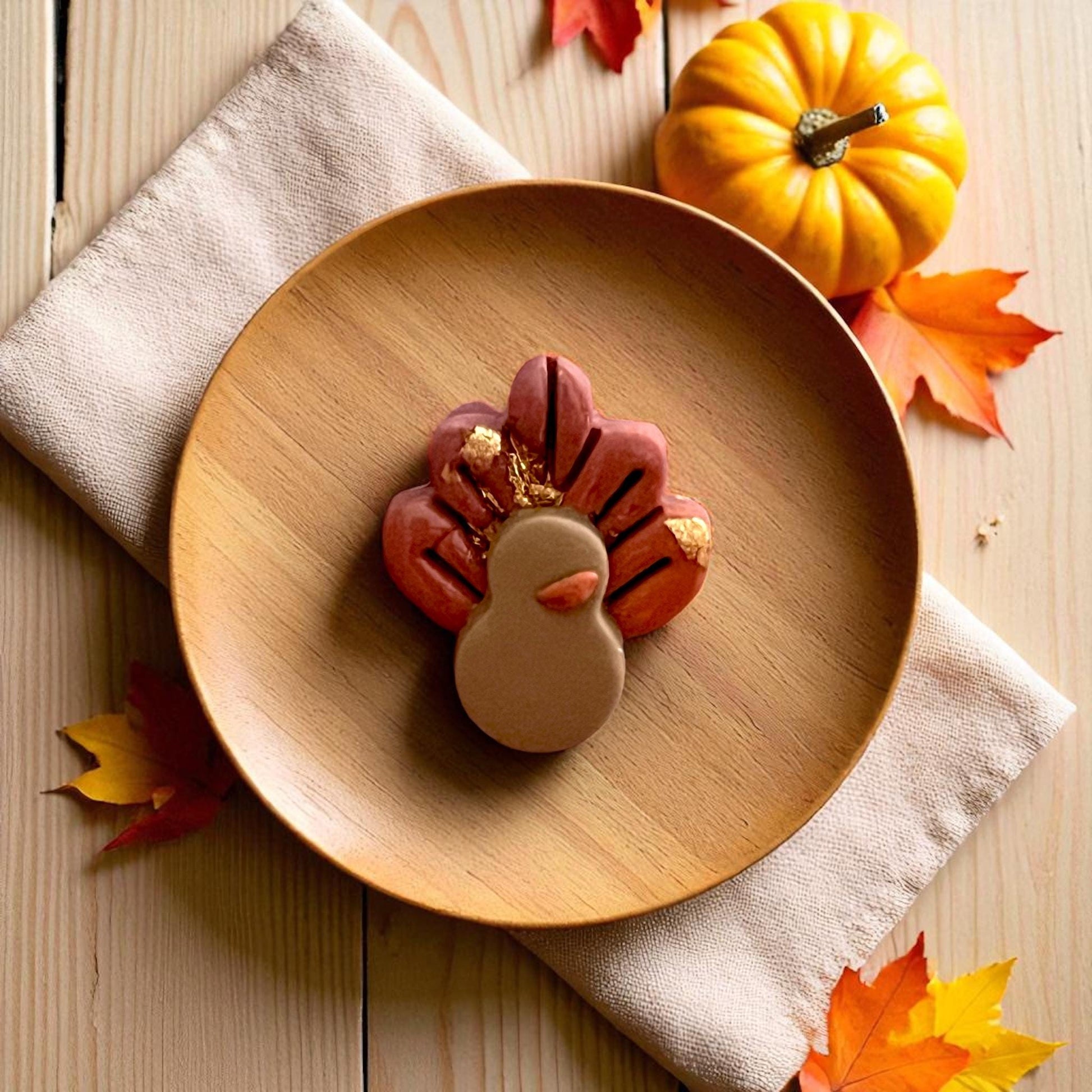 Turkey body and feather clay cutters displayed on white tile surrounded by pumpkins