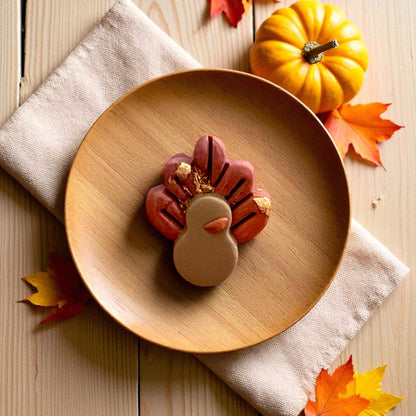 Turkey body and feather clay cutters displayed on white tile surrounded by pumpkins