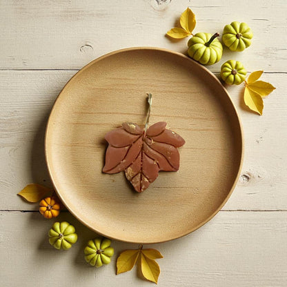 Small leaf clay cutter displayed on white tile with pumpkins and yellow leaves