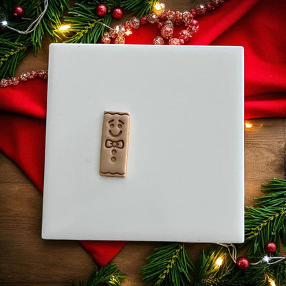 Gingerbread bar clay impression and cutter side by side on festive holiday backdrop
