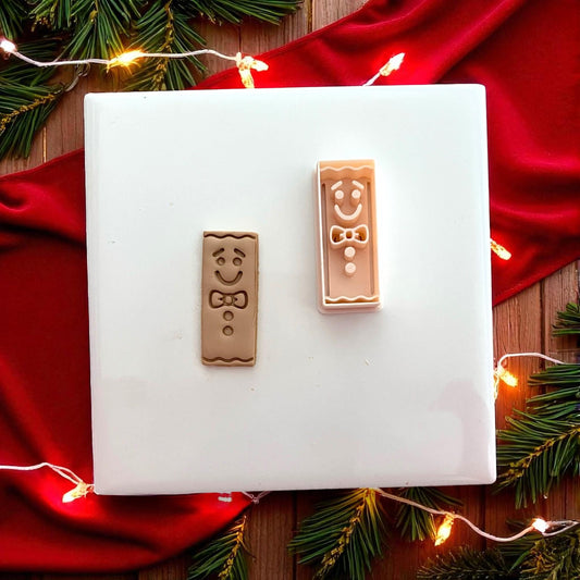 Gingerbread bar clay impression shown on white tile with red holiday fabric