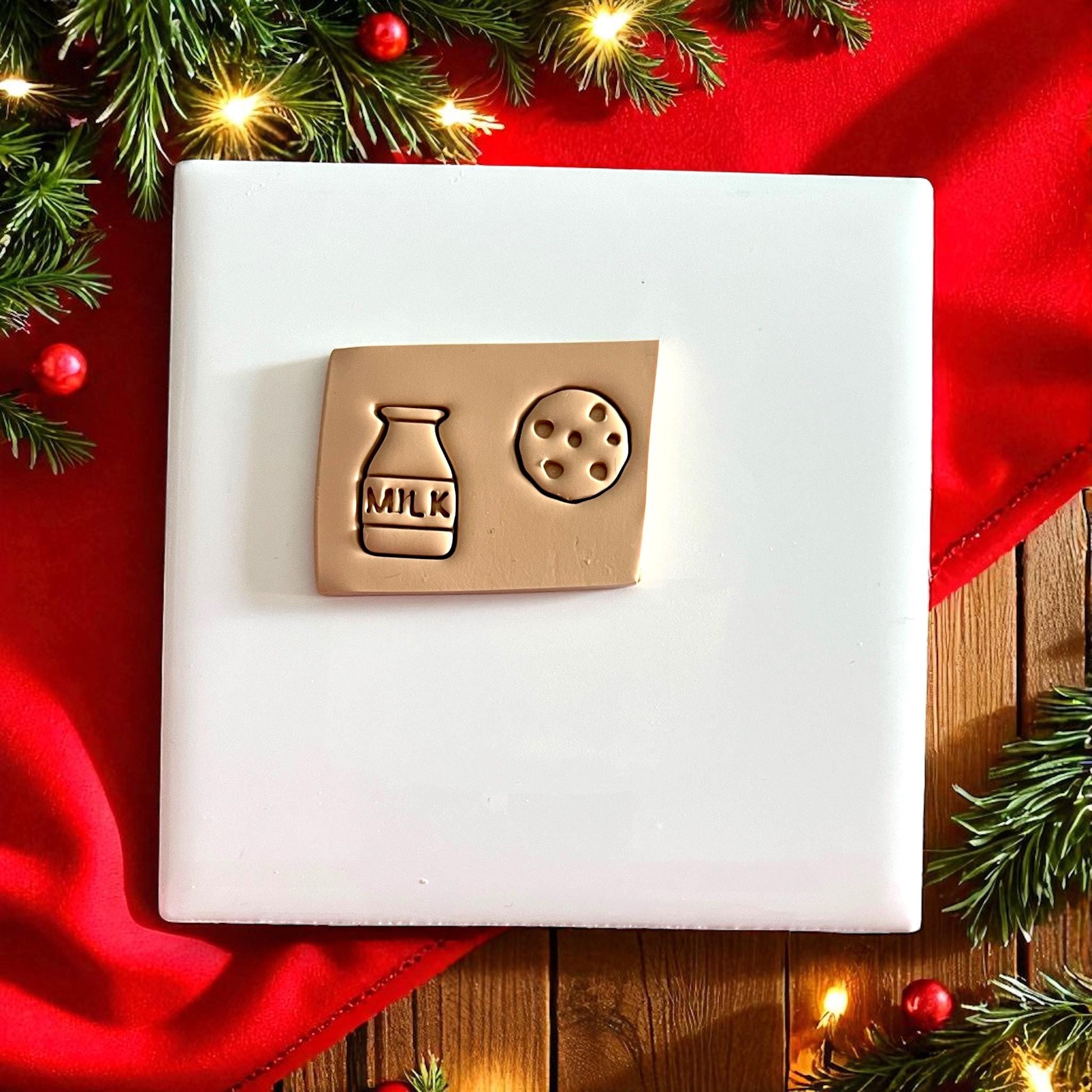 Close-up of milk and cookie clay shapes on a plate with holiday lights