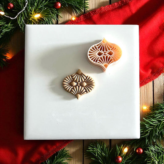 polymer clay ornament cutter and impression side by side on white tile