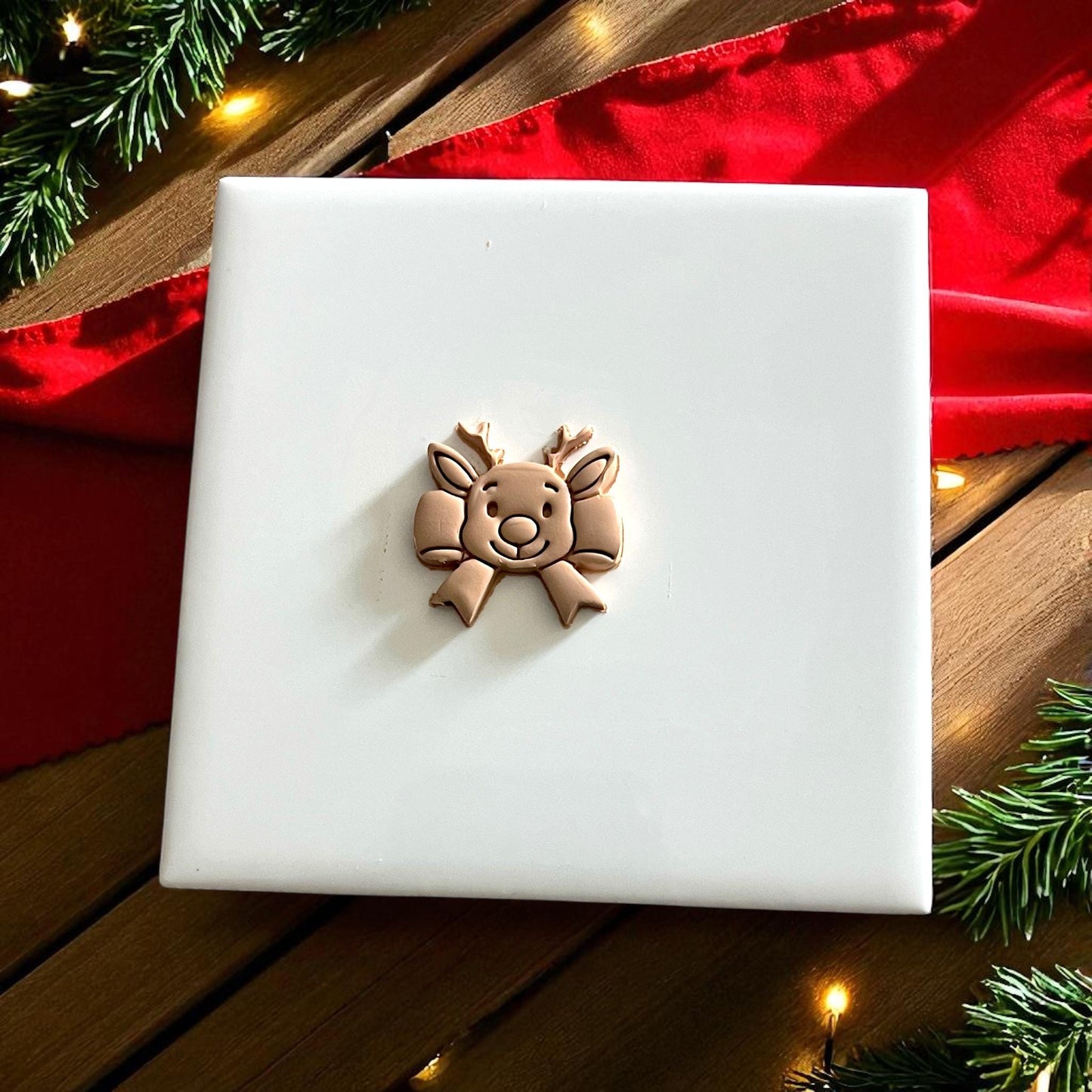 reindeer ribbon bow polymer clay imprint on beige clay sheet with Christmas decor