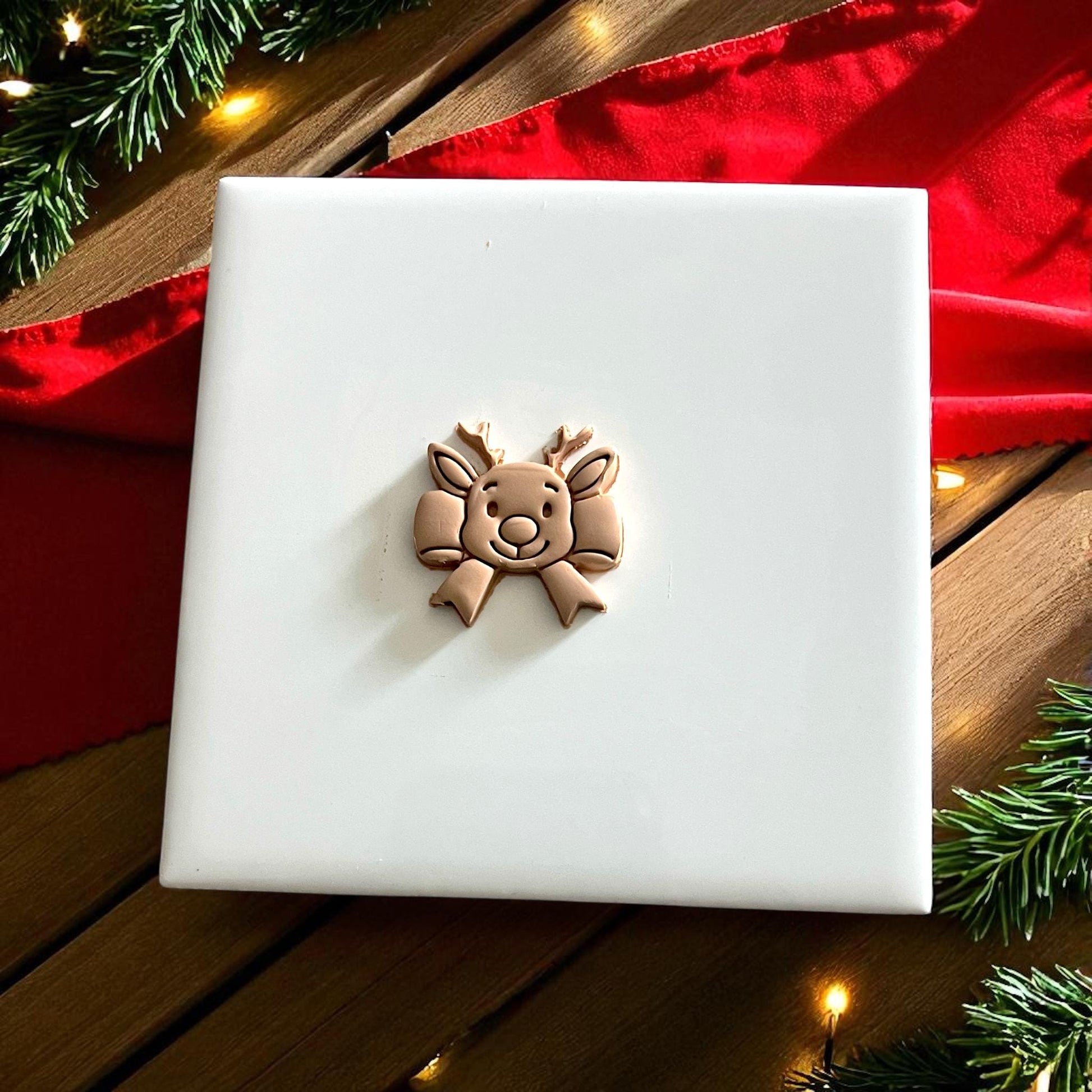 reindeer ribbon bow polymer clay imprint on beige clay sheet with Christmas decor