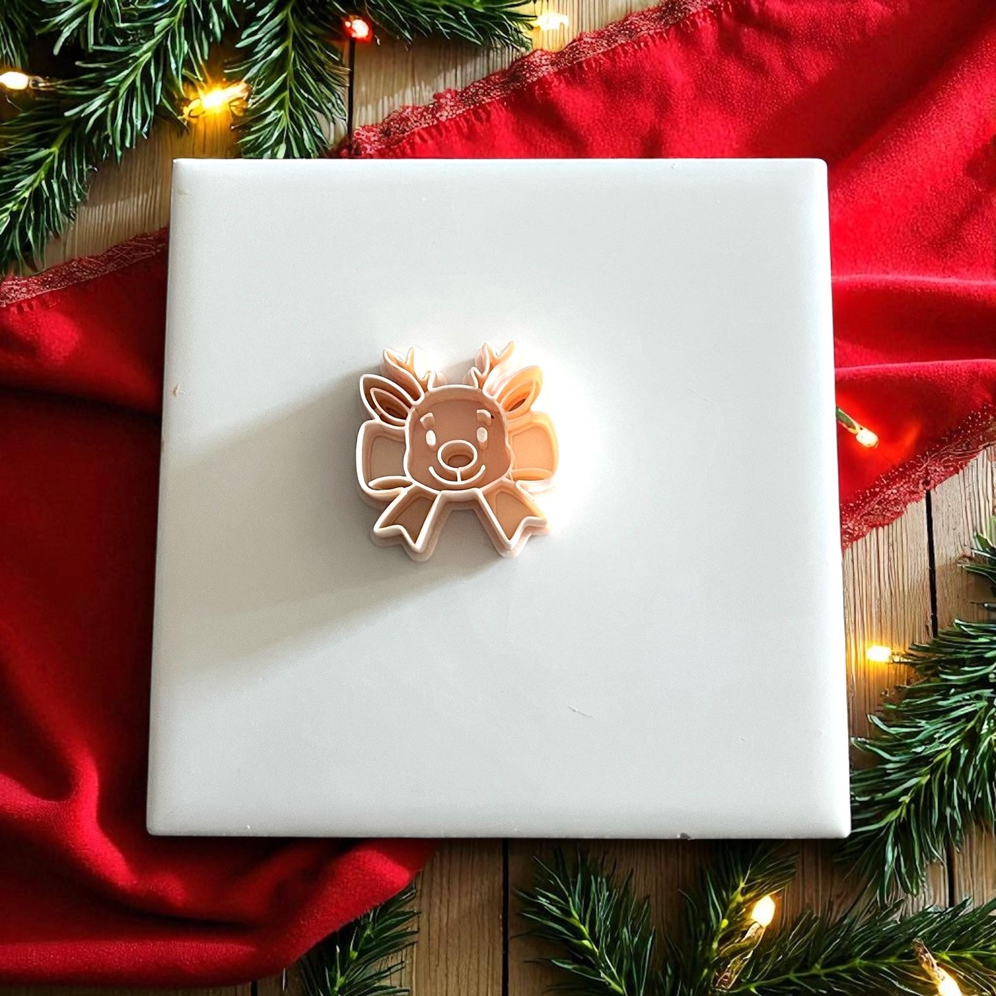 reindeer bow clay cutter displayed on white tile surrounded by Christmas decor