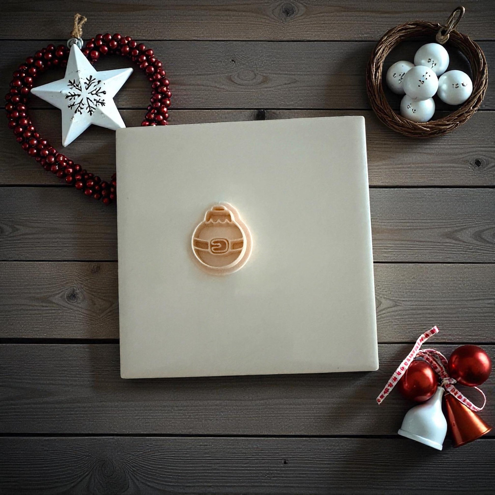 Santa belt ornament clay imprint on wooden background with Christmas ornaments