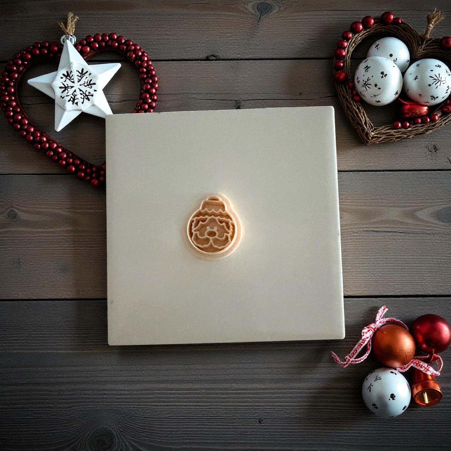 Small Santa ornament clay imprint centered on white tile with festive decor