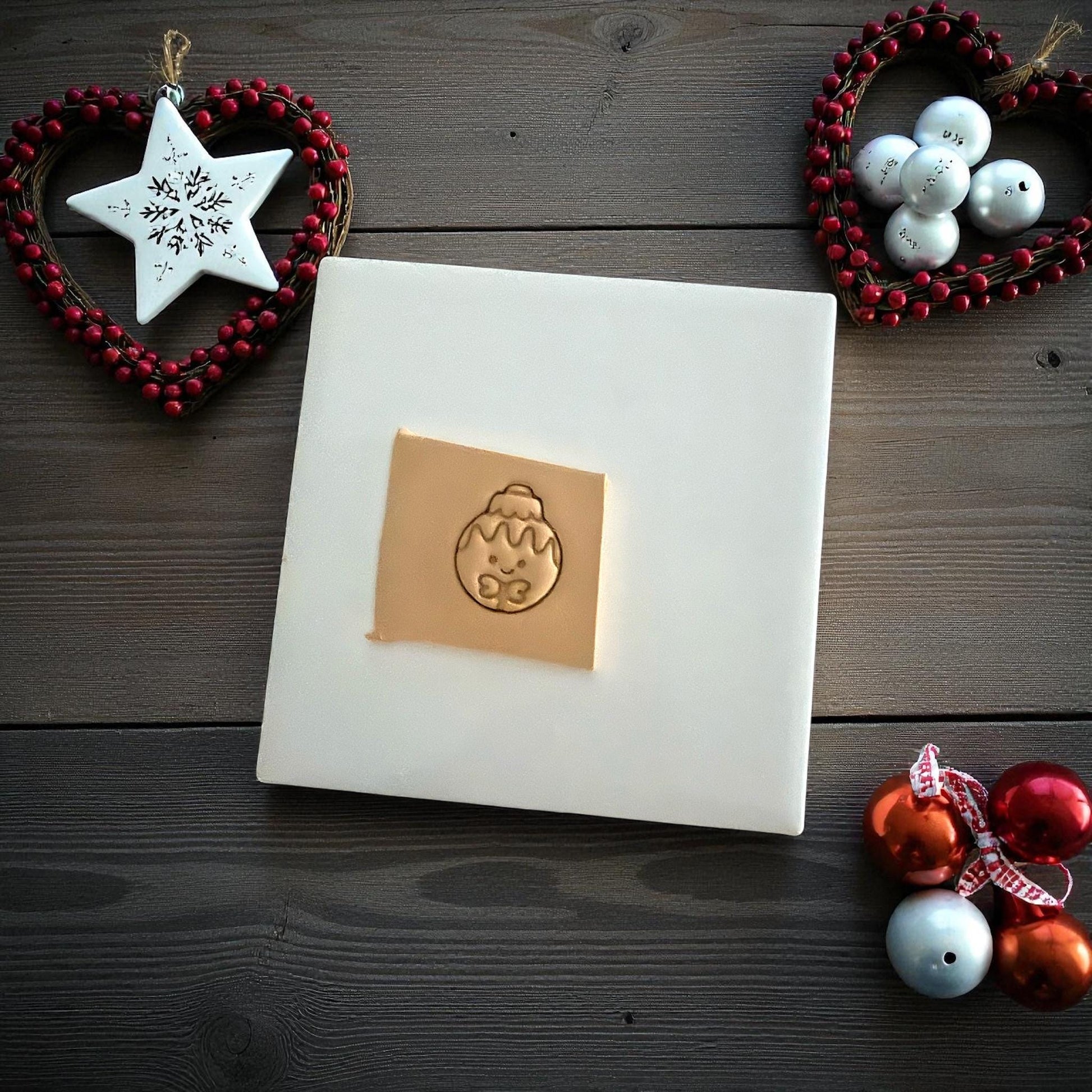 Gingerbread ornament clay imprint on tile with sculpting knife and holiday decor