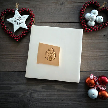 Gingerbread ornament clay imprint on tile with sculpting knife and holiday decor