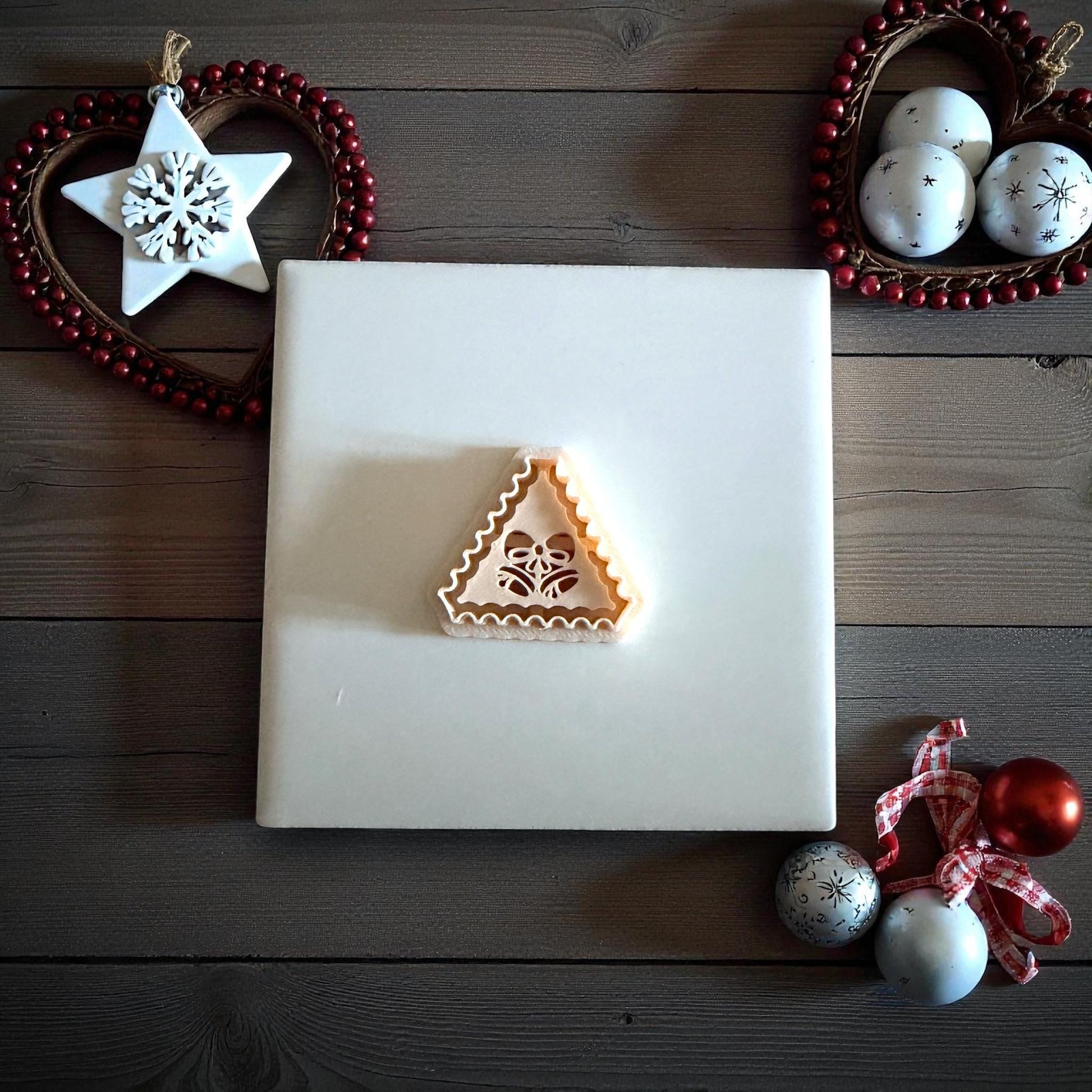 Jingle bell clay imprint centered on white tile with holiday decorations