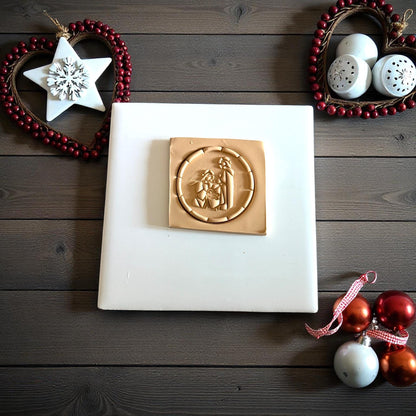 Round nativity clay imprint on wood background with star ornament and red beads