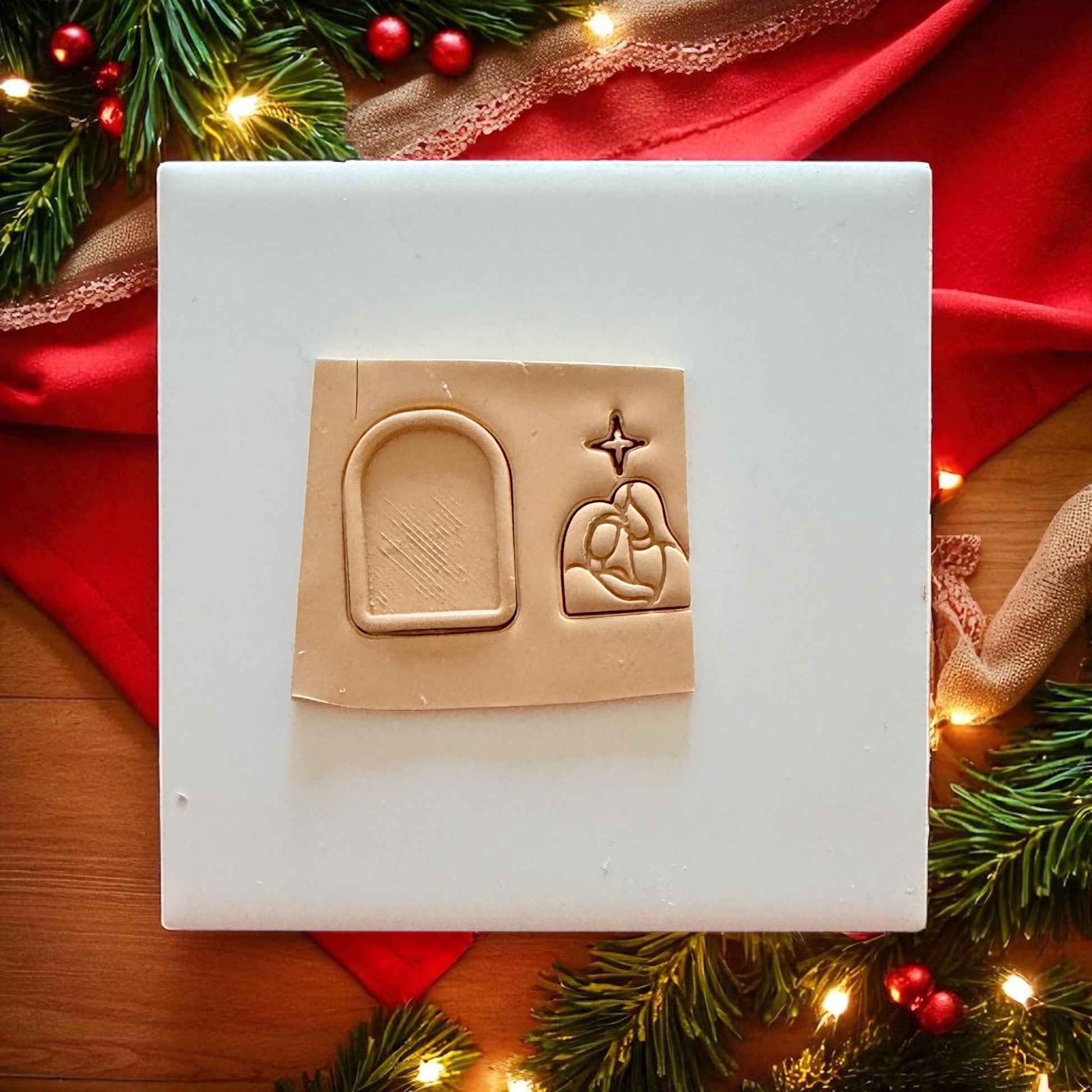 Clay slab with Nativity cutter impressions surrounded by Christmas lights