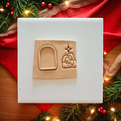 Clay slab with Nativity cutter impressions surrounded by Christmas lights