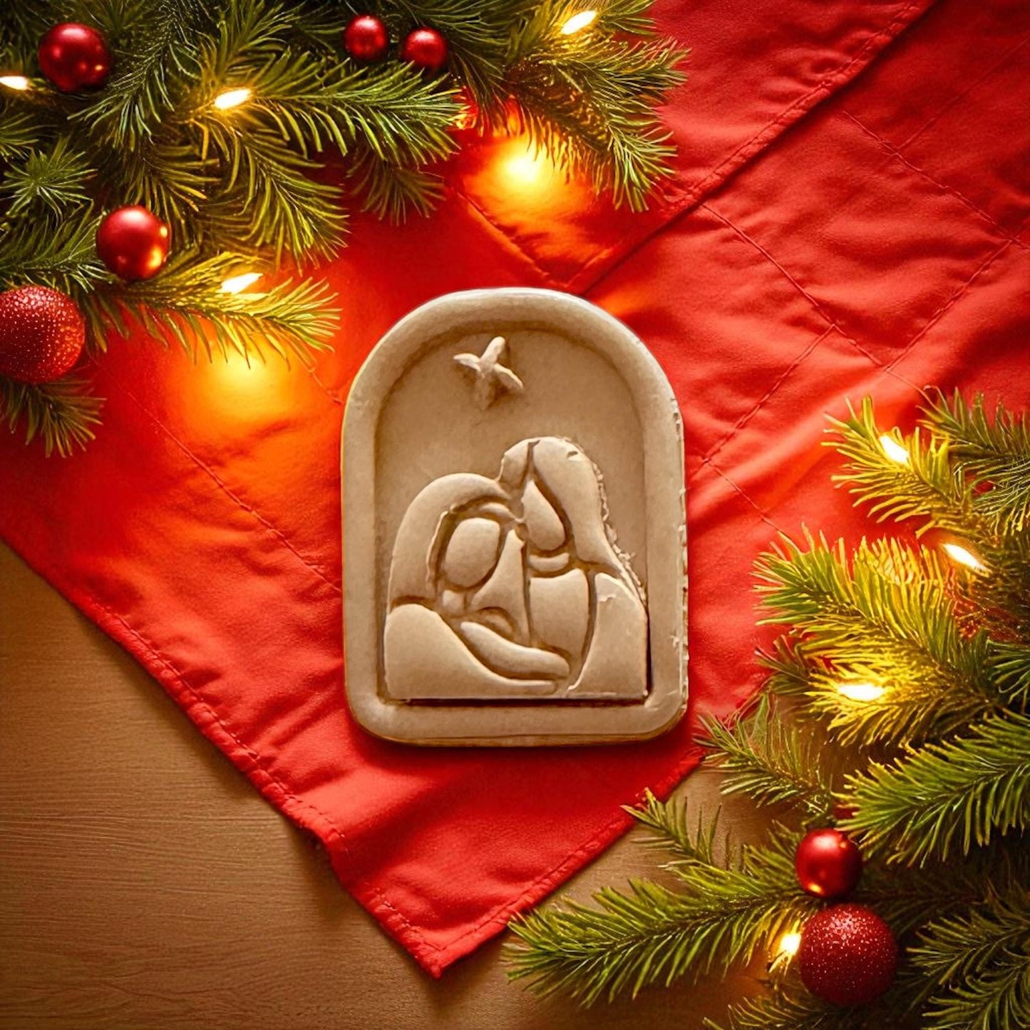 Nativity cutter set and clay piece displayed on red fabric with string lights