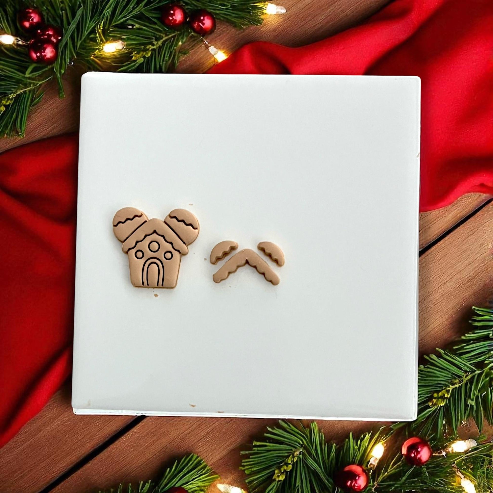 Gingerbread mouse house clay impression and roof detail on white tile with greenery