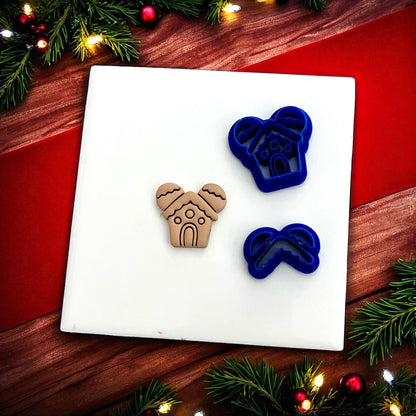 Gingerbread mouse house clay impression next to cutters on white tile with red and green background