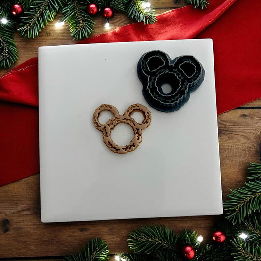 small clay wreath design on white tile surrounded by Christmas décor