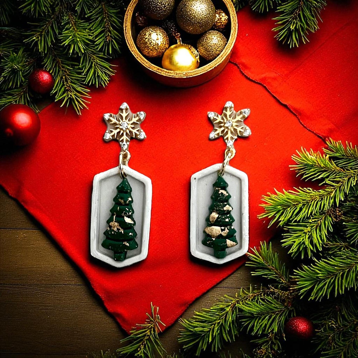 Green Christmas tree earrings inside geometric white frame with gold snowflake toppers