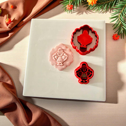 Red pilgrim turkey and scalloped cutters beside clay imprint on white tile with fall decor