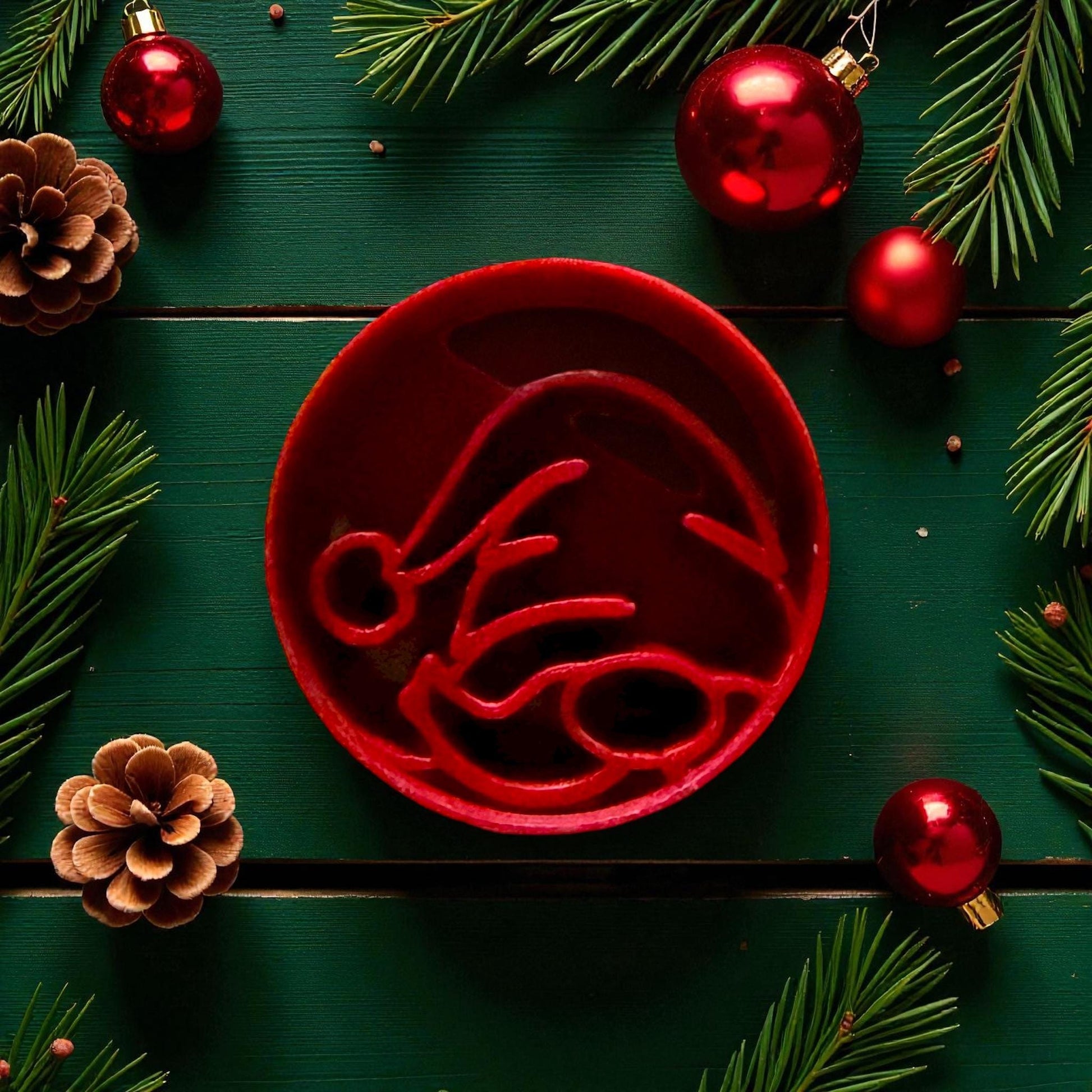 Close-up of red gnome cutter surrounded by pinecones and red ornaments